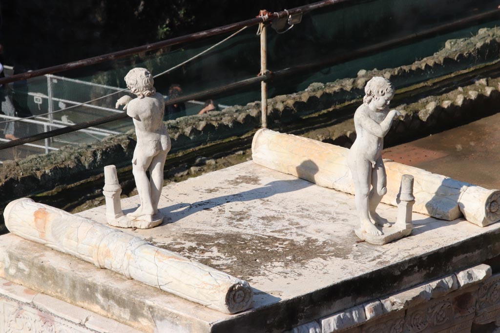 Herculaneum, October 2022.
On the top of the altar stand two marble statues of sleeping funeral figures which would have been leaning on torches, but which are now broken.
One of the two statues shows considerable traces of red-lead colour on their head of hair. Photo courtesy of Klaus Heese.